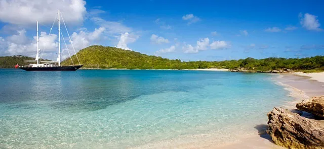 Exotic beach location with yacht in the distance